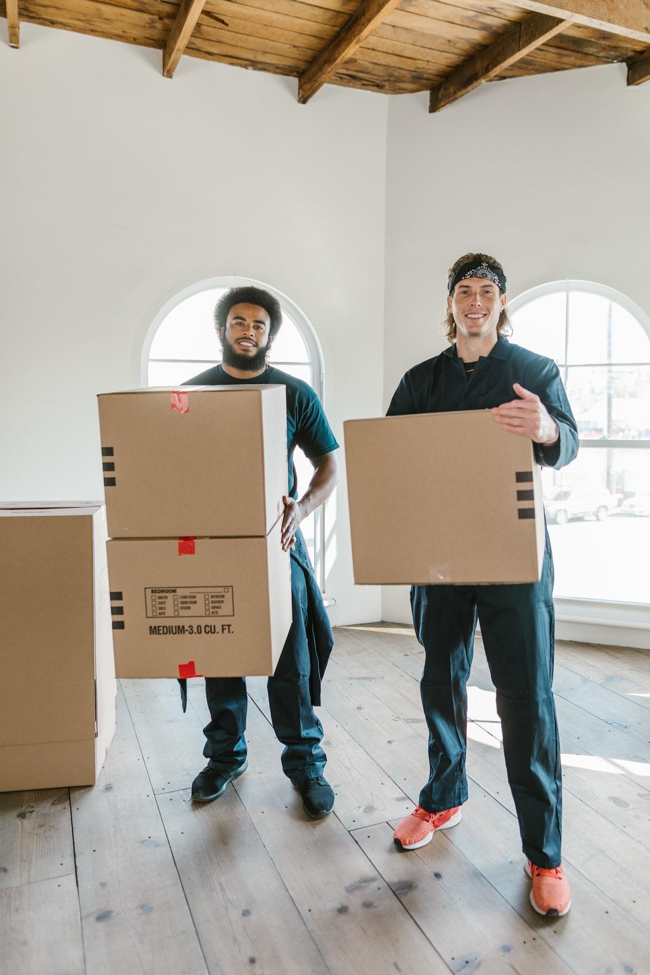 Two movers holding moving boxes